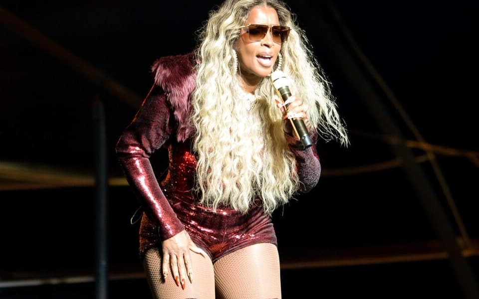 Mary J. Blige performing live on stage with a microphone