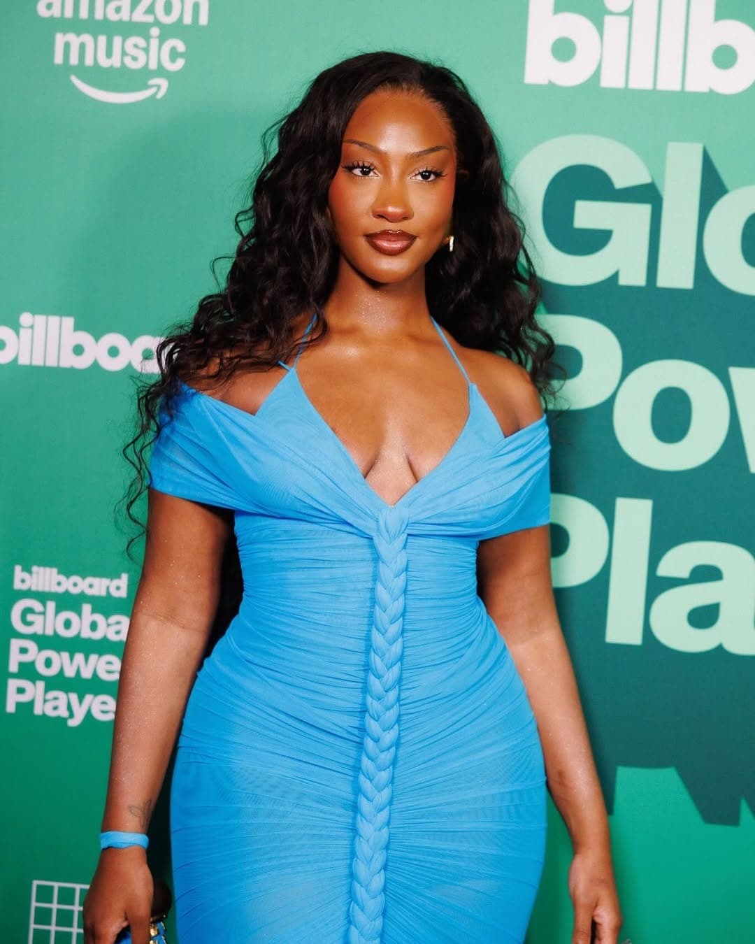 Tems poses in a blue dress at a Billboard event, 2025